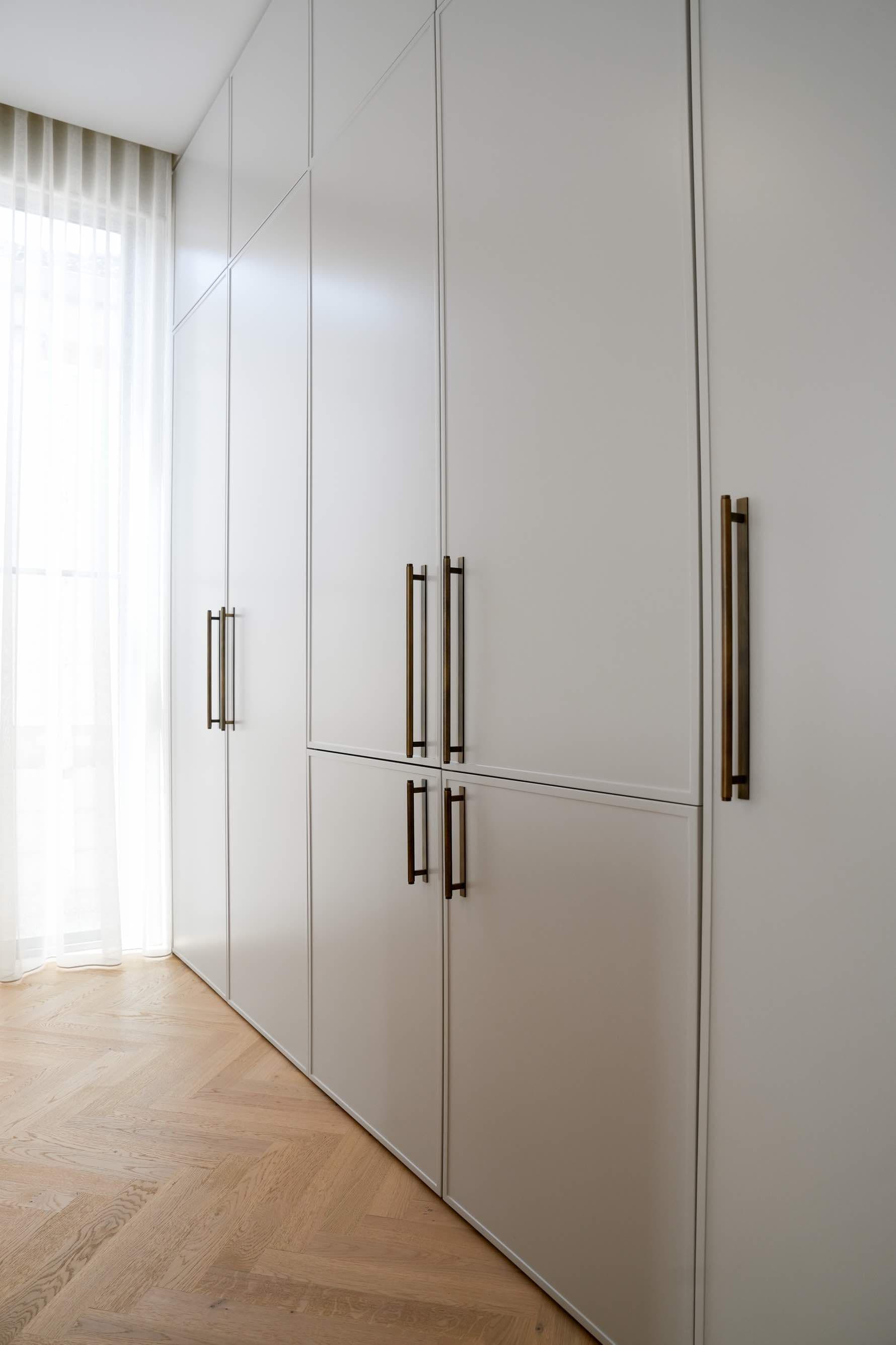 White built-in wardrobes with brass handles