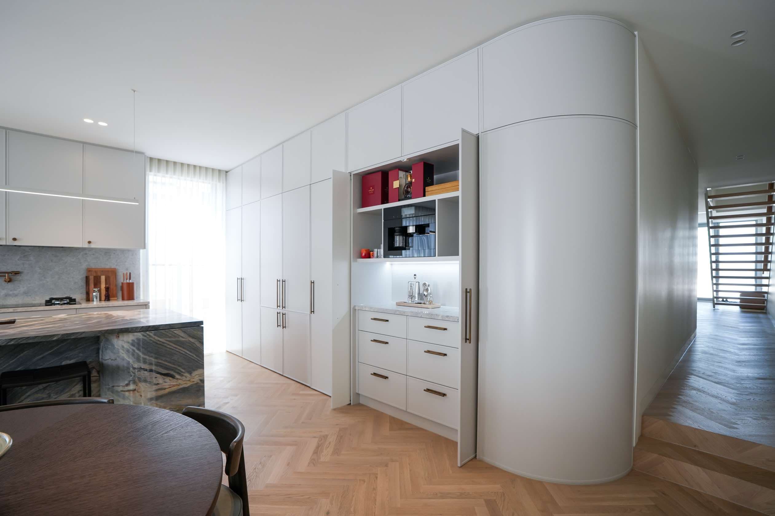 Custom curved cabinetry with integrated coffee station