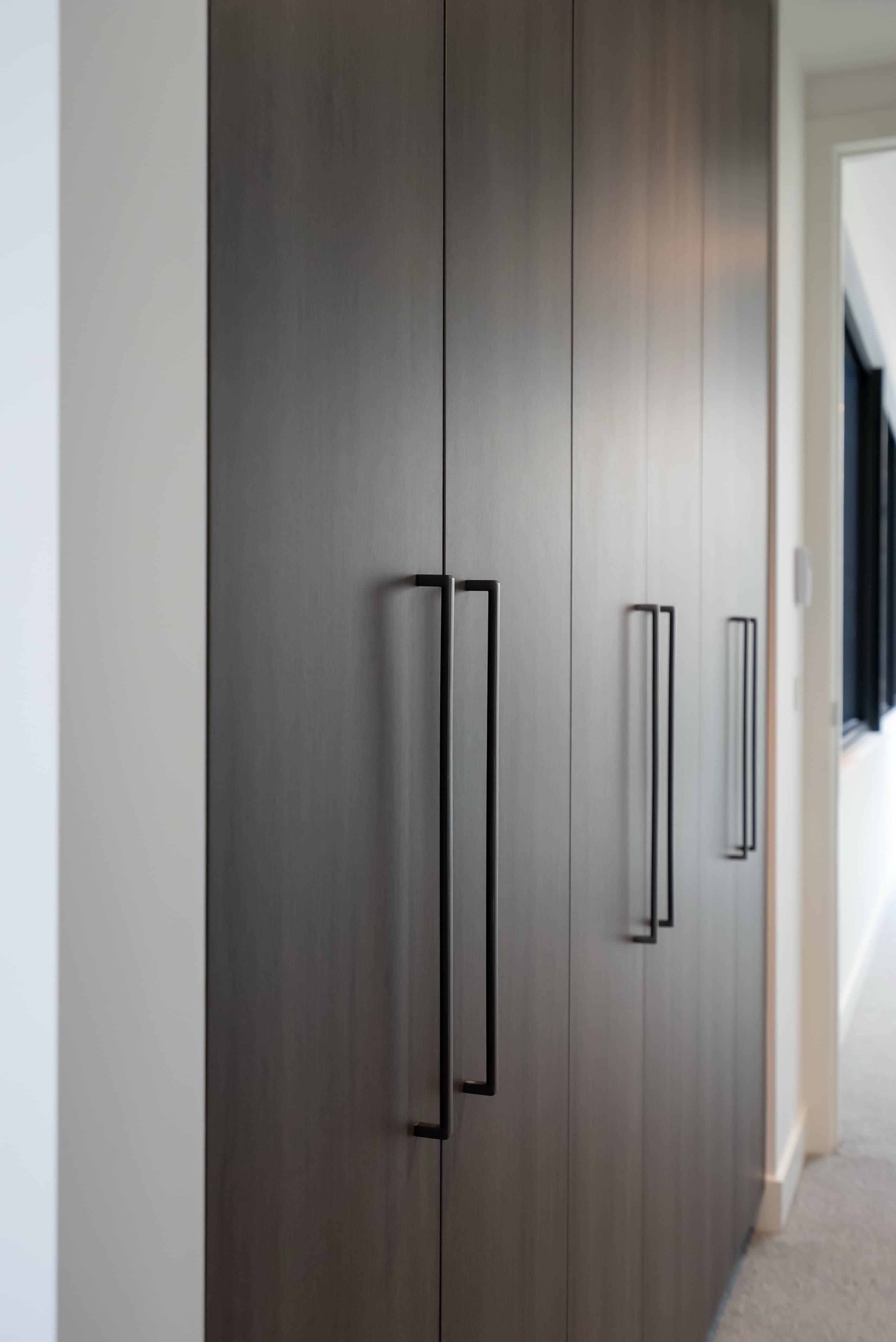 Dark timber wardrobe doors with black handles