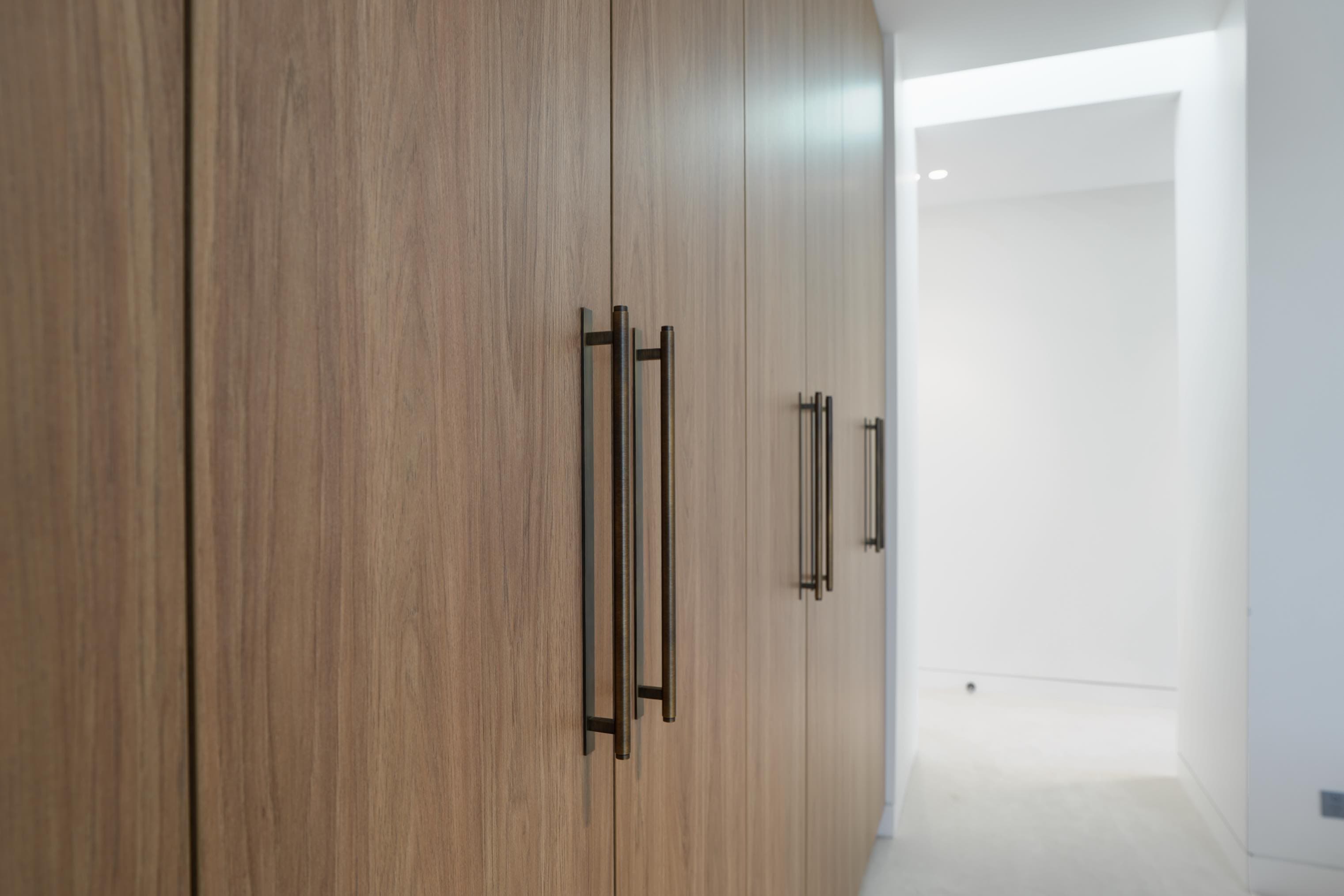 Timber wardrobes with bronze handles